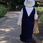 お買い物コーデ　30代　網バック　ネギ　スニーカー　エプロンワンピース　Vネック　白ブラウス　麻リネン　長袖