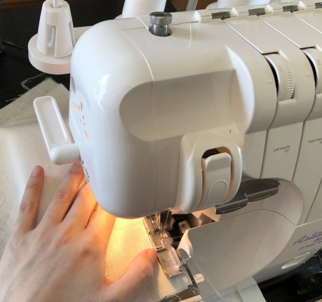 ロックミシン　かがり縫い　縫っている手　洋裁　ハンドメイド　丈直し　袖丈直し