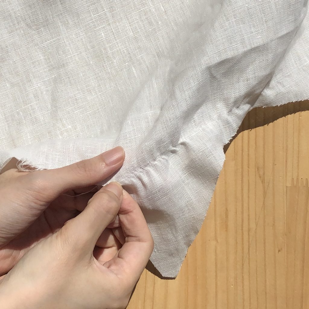 地の目直し糸を引っ張る手