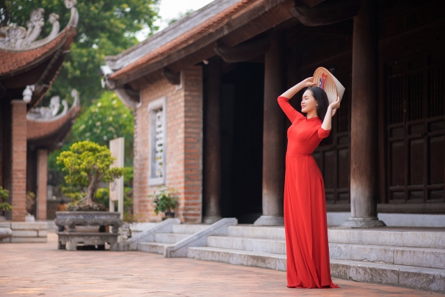 ベトナムアオザイ　民族衣装　赤いアオザイを着た女性　寺院