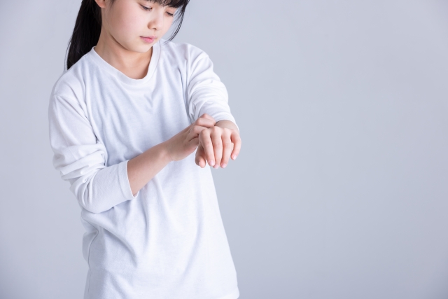ダニ　腕をかく女の子