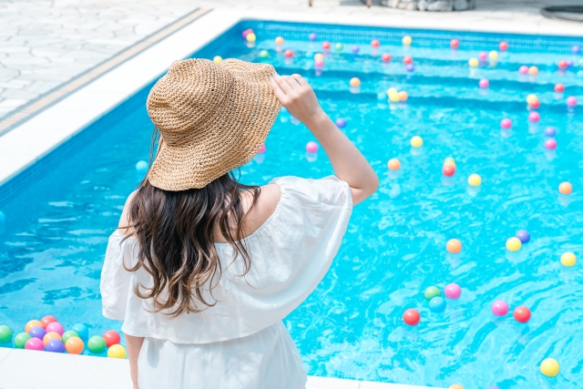 紫外線　プールで帽子をかぶる女性