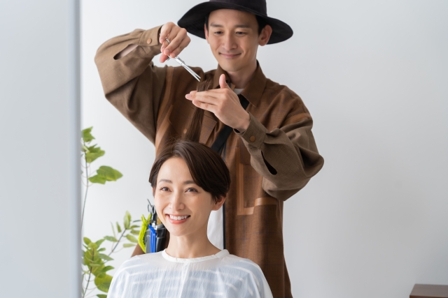 ヘアカットをする女性と美容師